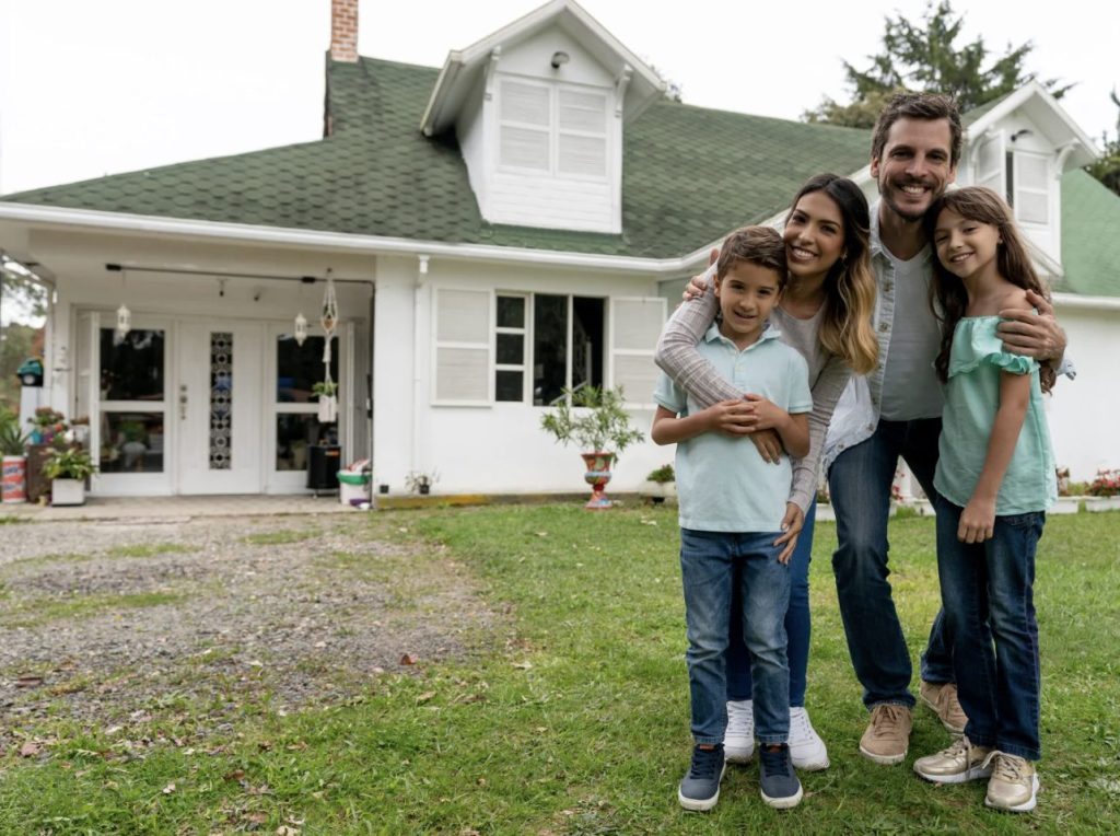 Family in front of their home after selecting the best homeowners insurance quote.
